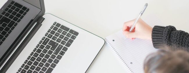 Laptop notepad and person writing with a pen
